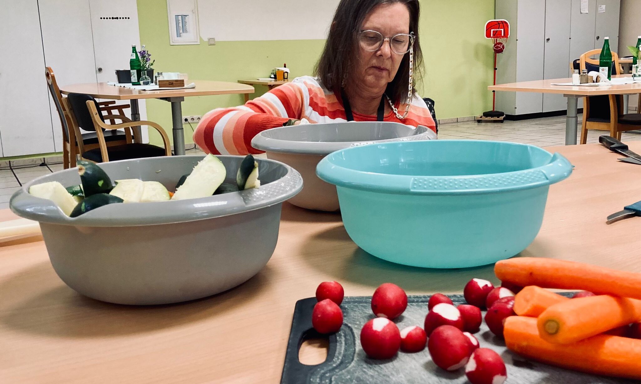 Bewohnerin schneidet Gemüse